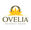 Logo d'Ovelia Résidences Seniors représentant un lotus jaune stylisé au-dessus du nom OVELIA en lettres grasses, avec RÉSIDENCES SENIORS écrit en dessous en plus petit texte.
